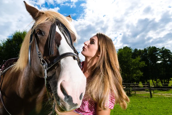 Mladá žena na louce s koněm a líbání — Stock fotografie