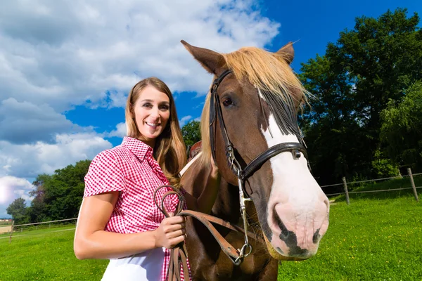 Jonge vrouw op de weide met paard — Stockfoto