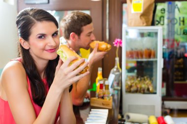 Customers eating Hotdog in fast food snack bar clipart