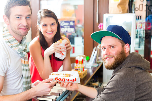 Customers eating Hotdog in fast food snack bar