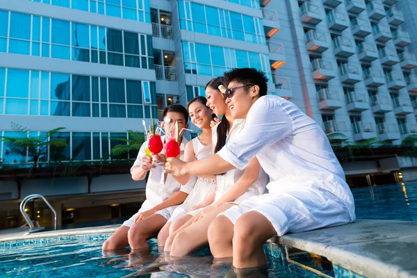 Čínské páry pití koktejlů v baru u bazénu hotelu — Stock fotografie