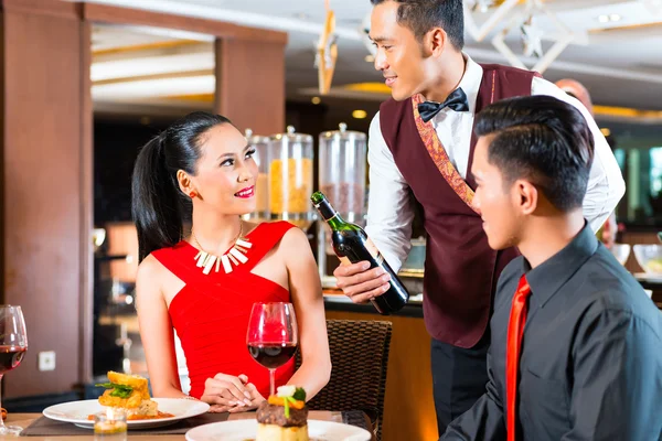 Young Asian couple dining in restaurant — Stock Photo, Image