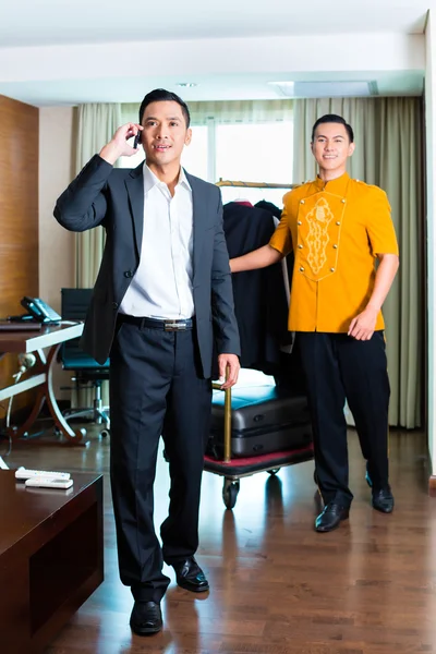 Guest and bell boy standing in hotel room — Stock Photo, Image