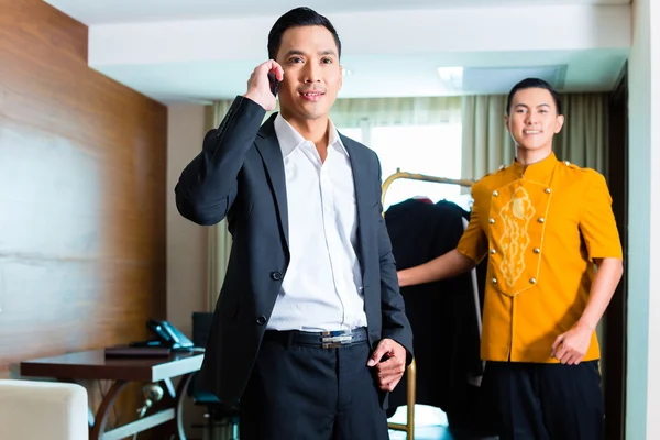 Guest and bell boy standing in hotel room — Stock Photo, Image