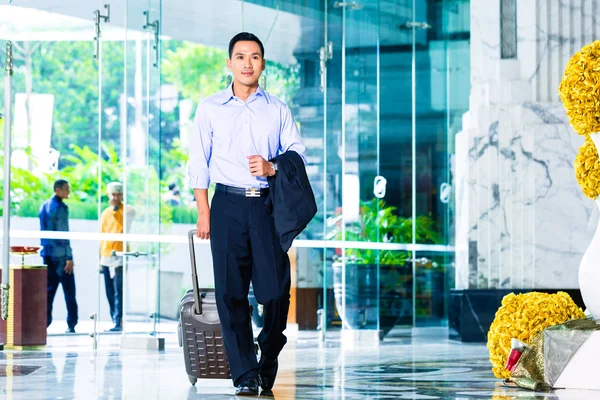 Asian man walking in hotel lobby — Stok fotoğraf