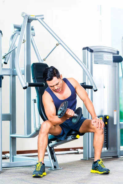 Asiatique homme levant poids de la main à la salle de gym — Photo