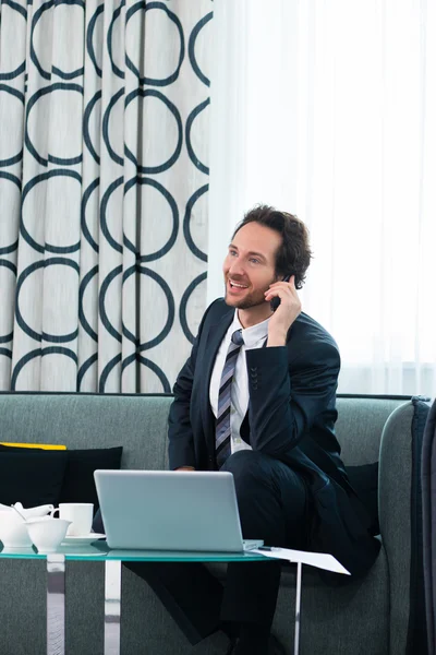 Businessman in hotel is on the phone — Stock Photo, Image