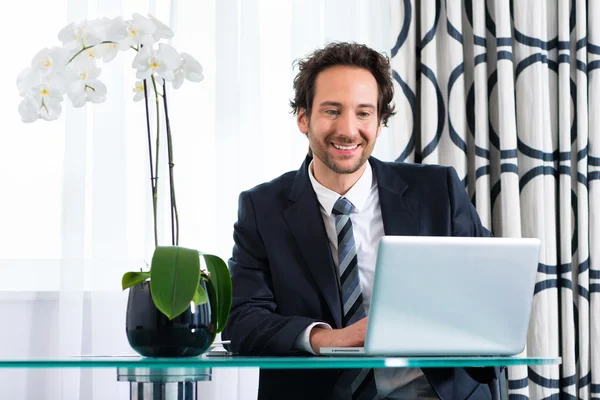 Homme d'affaires à l'hôtel travaillant sur ordinateur portable — Photo