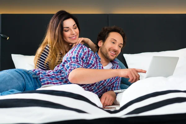 Couple in Hotel in bed with wifi and computer — Stockfoto