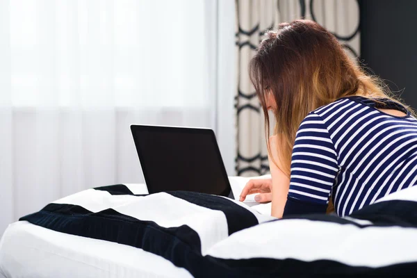 Mujer en el hotel en la cama con wifi y ordenador —  Fotos de Stock