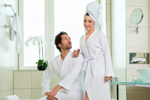 Young couple in bathrobe in hotel bathroom — Stock Photo, Image