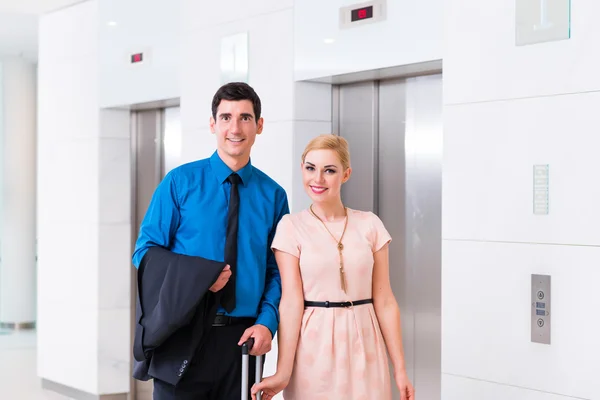 Homem e mulher chegando ao lobby do hotel com mala — Fotografia de Stock