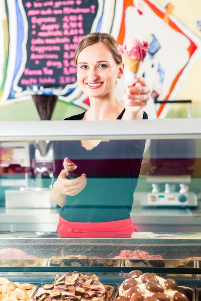 Sales girl handing wafer of ice cream over counter — Stock Photo, Image
