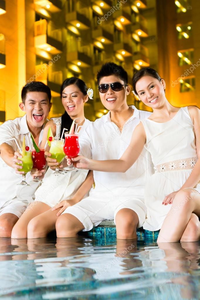 Chinese couples drinking cocktails in hotel pool bar — Stock Photo
