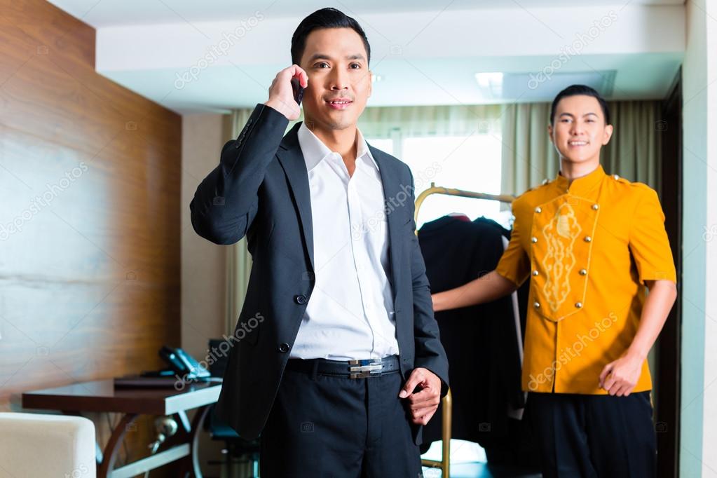 Guest and bell boy standing in hotel room
