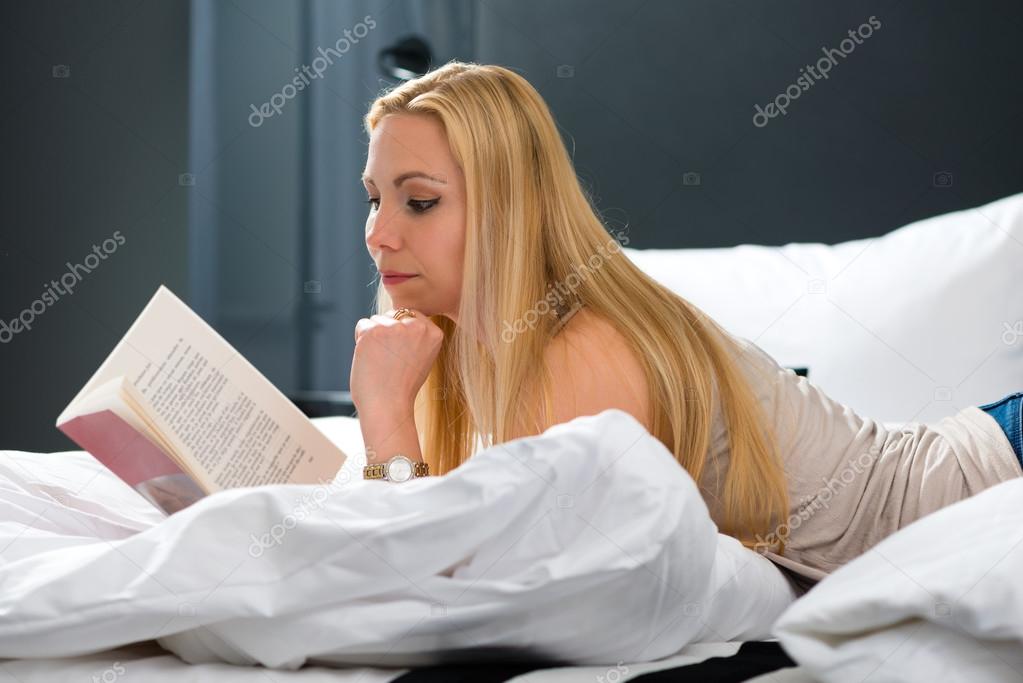 woman in Hotel reading book in bed