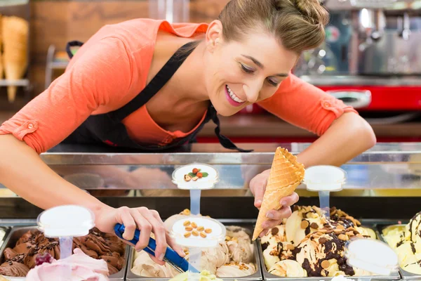 Female seller in Parlor with ice cream cone — Stockfoto