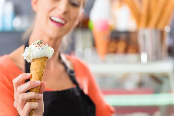 Vendedor feminino em salão com cone de sorvete — Fotografia de Stock