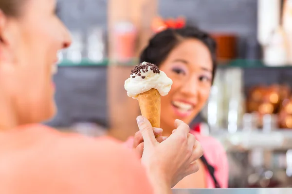 Жіночий продавець в салоні з конусом морозива — стокове фото