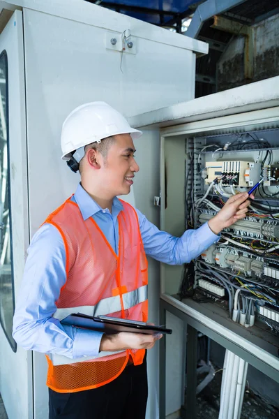 Electricista asiático en panel en obra —  Fotos de Stock
