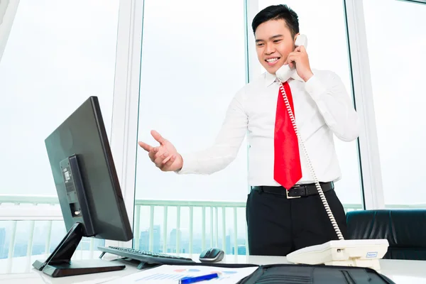 Asiatique homme d'affaires au téléphone travaillant dans le bureau — Photo