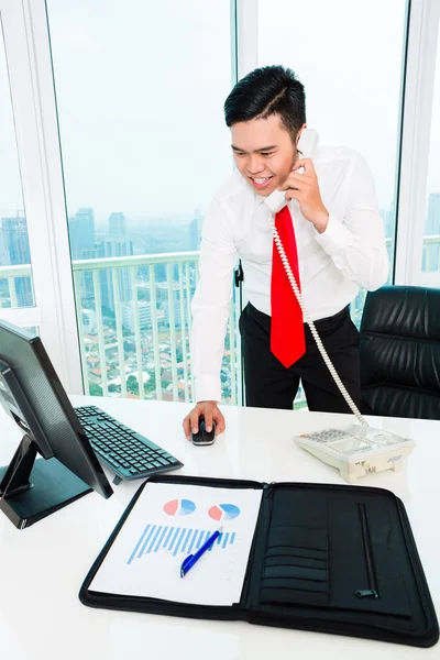 Asiático homem de negócios no telefone trabalhando no escritório — Fotografia de Stock