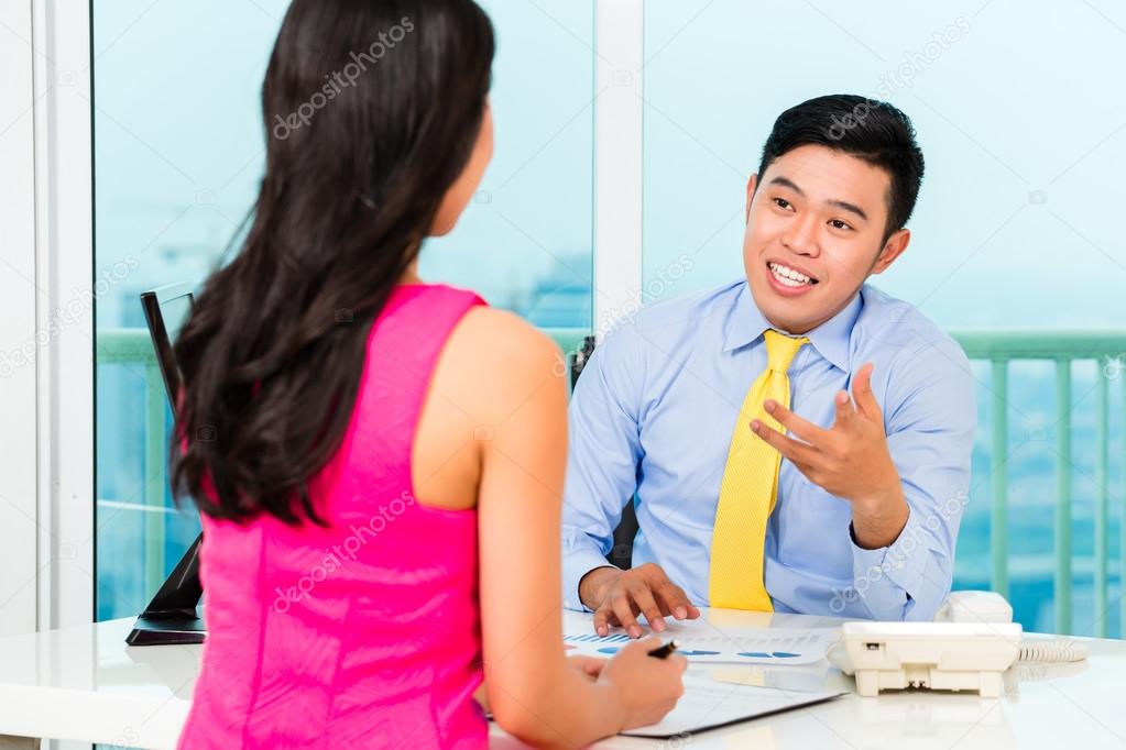 Asian advisor with client on financial investment