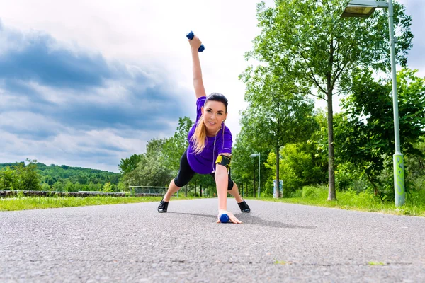 Ung kvinna gör fitness i park — Stockfoto