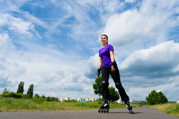 Mujer joven patinando en parque — Foto de Stock