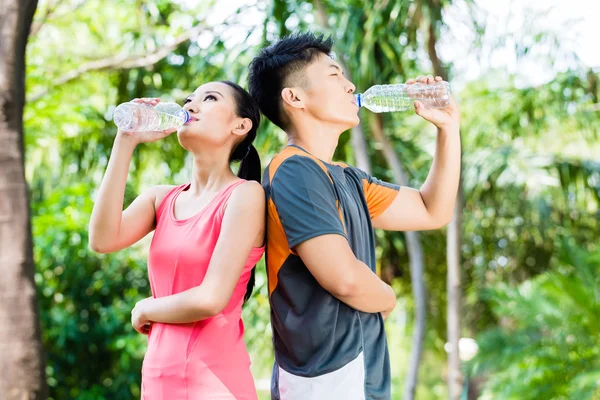 Paar trinkt Wasser nach Sport im Park — Stockfoto