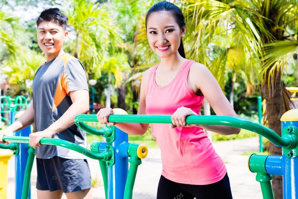 Chinese sport friends in outdoor fitness gym
