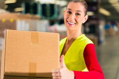 worker holds package in warehouse of forwarding
