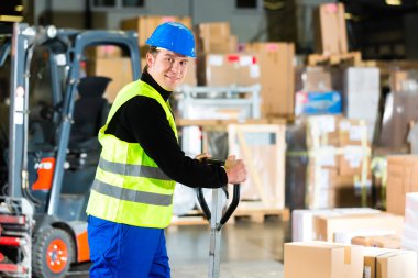 Storeman with mover at warehouse of forwarding clipart
