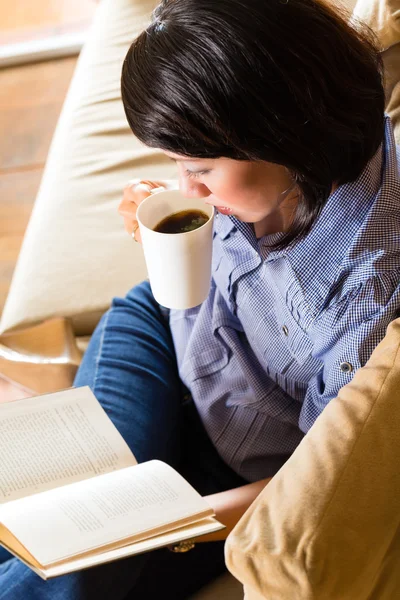 Asiatisk tjej med cup läser bok — Stockfoto