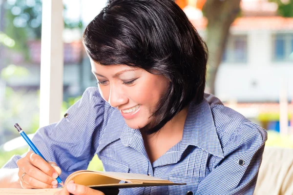 Meisje met stapel boeken leren — Stockfoto