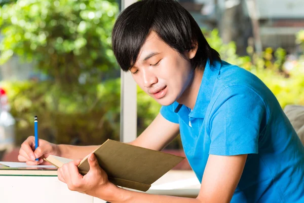 Asiatique étudiant lecture livre ou manuel d'apprentissage — Photo