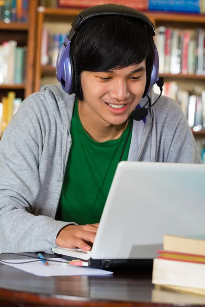 Laptop ve kulaklık ile kütüphane erkekte — Stok fotoğraf