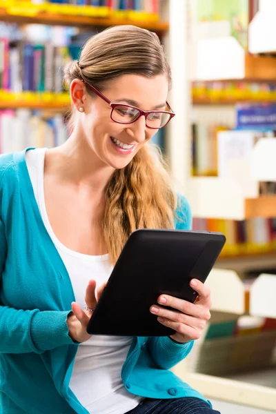 Estudante em aprendizagem de biblioteca com computador tablet — Fotografia de Stock