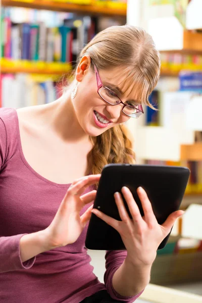 Estudante em aprendizagem de biblioteca com computador tablet — Fotografia de Stock