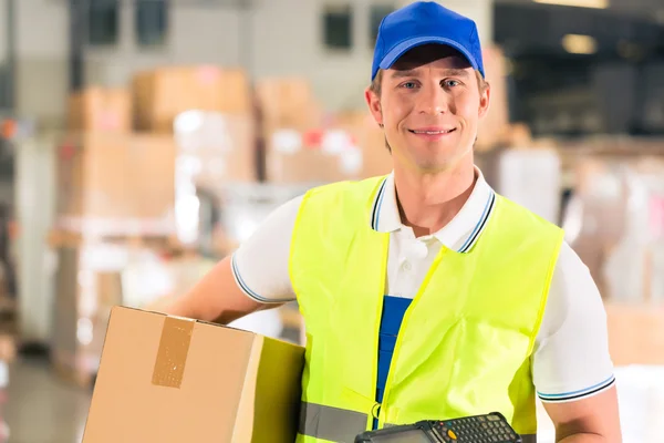 Il lavoratore tiene il pacco in magazzino d'inoltro — Foto Stock