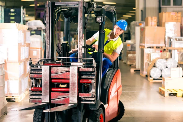 Forklift driver at warehouse of forwarding