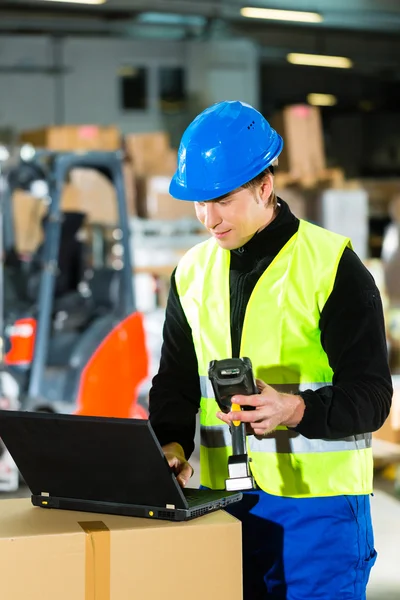Worker with scanner and laptop at forwarding — Stock Photo, Image