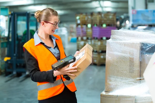 Female worker scans package in warehouse of forwarding — Zdjęcie stockowe