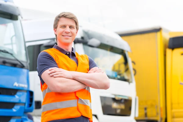 Forwarder or driver in front of trucks in depot — Stock Photo, Image