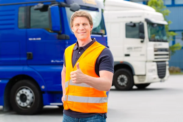 Forwarder en frente de camiones en un depósito — Foto de Stock