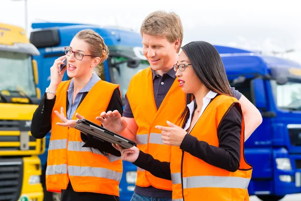 Forwarder in front of trucks on a depot — Stock Photo, Image