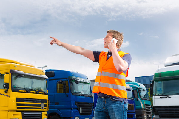 Forwarder in front of trucks on a depot