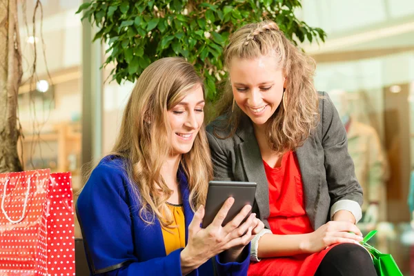 Twee vrouwen winkelen met zakken in winkelcentrum — Stockfoto