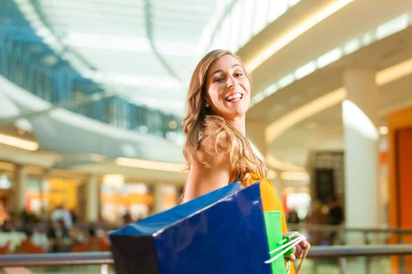 Mujer joven de compras en el centro comercial con bolsas —  Fotos de Stock