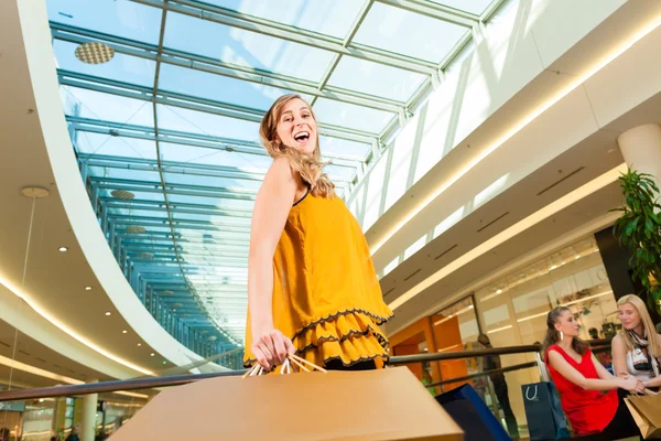 Young woman shopping in mall with bags — Stock Photo, Image